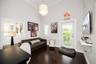 Vaulted ceilings, dark wood-finish flooring, plantation shutters, a multi-tiered crystal pendant light fixture, and a glass-paneled exterior door