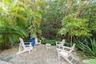 Gravel patio area featuring mature tropical palms and dense perimeter greenery
