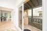 Covered balcony featuring stone tile flooring and a vertical balustrade, accessed through full-height sliding glass doors