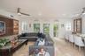 Open living space featuring stone flooring, arched windows, recessed lighting, built-in wooden display shelving, and dual ceiling fans