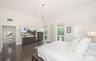 High ceilings, dark tile flooring, multi-arm sputnik chandelier, and expansive windows with custom roller shades