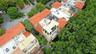 Aerial perspective featuring multi-story structures with terracotta tile roofing, stucco exteriors, upper-level balconies, and rooftop terraces