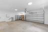 Multi-car garage featuring a concrete floor, automated sectional door, and flush-mount ceiling lighting