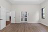 Room featuring high ceilings, wood-finish flooring, glass-paneled French doors, and a multi-pane window