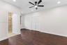 Wood-finish flooring, recessed lighting, ceiling fan with integrated light, and two sets of louvered-style closet doors