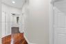 Interior hallway featuring wood-finish flooring, recessed lighting, and multi-panel interior doors