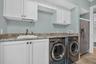 Downstairs laundry room with folding area and second fridge