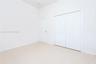 Interior space featuring neutral wall paint, polished tile flooring, a solid-panel door, and a dual-panel sliding closet