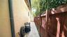 Side yard featuring a paved walkway, stucco exterior wall, and wood privacy fencing