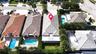Aerial perspective featuring a concrete tile roof, covered rear patio, and expansive lawn area within a residential setting