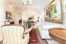 Open-concept interior featuring tray ceilings, arched entryways, multi-light chandeliers, and neutral tile flooring