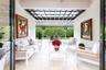 Covered patio featuring stone tile flooring, a geometric pergola ceiling structure, and matte black-framed double entry doors