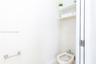 Bidet with chrome fixtures, two wall-mounted shelves, and a wall-mounted metal towel bar