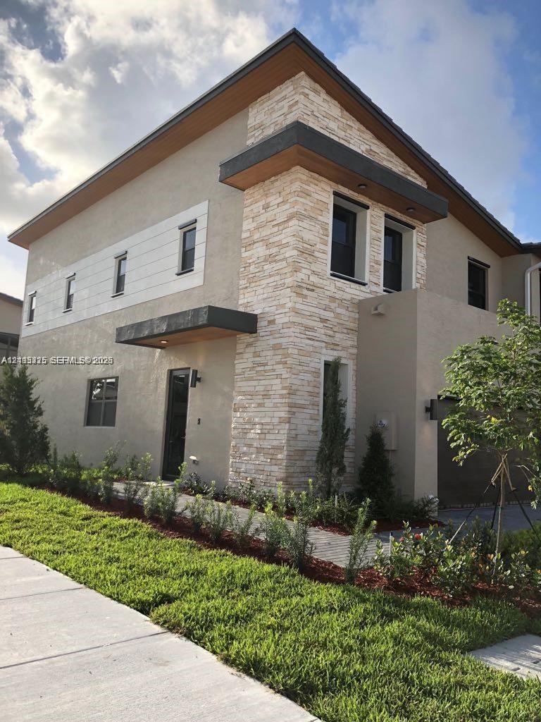 Contemporary multi-story exterior featuring stone veneer accents, smooth stucco finish, horizontal plank siding, and overhanging roof eaves with reces