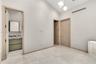 Vaulted ceilings featuring multi-pendant spherical lighting, light-toned wood-finish interior doors, and large-format neutral tile flooring