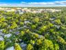 Aerial perspective of a tree-lined residential area featuring dense canopy cover, established vegetation, and proximity to urban infrastructure