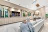 Vaulted ceilings, extensive custom cabinetry with light wood-finish detailing, recessed lighting, multi-light linear pendant fixture, and large-format