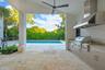 Covered outdoor kitchen featuring stainless steel cabinetry, a professional-grade grill, and a matching range hood, complete with natural stone floori