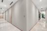 Hallway featuring high-gloss tile flooring, recessed ceiling lighting, linear ceiling diffusers, and wood-finish interior doors