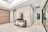 Foyer featuring large-format light-toned tile flooring, recessed ceiling lighting, a recessed tray ceiling, a large wood-finish door, and glass-panele