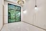 Interior space featuring high ceilings, polished stone-finish flooring, a multi-pane sliding glass door, a tiered metal chandelier, and a pendant ligh