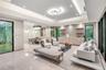 Expansive open-concept living area featuring a recessed tray ceiling with integrated cove lighting, polished stone flooring, custom built-in cabinetry
