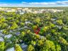 Aerial perspective featuring a heavily wooded residential lot with established mature trees and dense perimeter vegetation