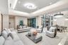 Expansive living area featuring a tray ceiling with recessed lighting, large-format polished flooring, floor-to-ceiling glass wall panels with dark fr