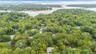 Aerial perspective featuring a heavily wooded landscape with mature trees and proximity to coastal water channels