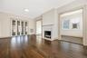Wood flooring, fireplace with a decorative mantel, multi-pane glass doors, and window-lined interior space