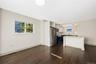 Eat in kitchen leading into the Dining room featuring two-tone navy and white shaker cabinetry, quartz countertops, stainless steel appliances, a cent