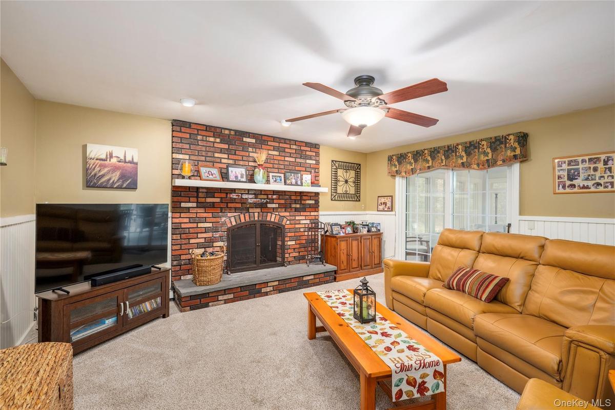 Brick Fireplace featuring a stone hearth with slider to enclosed 4 Season Room