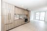 Contemporary kitchen featuring wood-finish cabinetry, integrated refrigerator, stone-patterned backsplash, recessed lighting, and large format tile fl