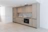 Kitchen featuring flat-panel wood-finish cabinetry, integrated panel-ready refrigerator, stone-patterned backsplash, built-in wall oven, and light-ton