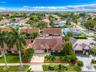 Single-story residence featuring a tile roof, stucco exterior, two-car garage, and established landscaping with palm trees