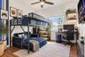 Wood-finish flooring, ceiling fan with integrated light fixture, large multi-pane window, and two floating wall shelves with recessed accent lighting