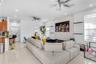 Living area featuring a floor-to-ceiling natural stone veneer accent wall, recessed lighting, ceiling fans, large-format tile flooring, and integrated