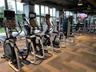 Fitness center featuring floor-to-ceiling windows, patterned carpet tile flooring, exposed industrial-style ceiling, and multi-station exercise equipm
