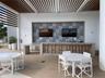 Outdoor covered patio featuring a slatted pergola ceiling, concrete bar with patterned tile backsplash, and wood-finish flooring