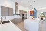 Kitchen featuring flat-panel wood-finish cabinetry, white countertops, a stainless steel chimney-style range hood, subway tile backsplash, and a large