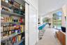 Walk-in pantry featuring adjustable wire shelving and a sliding shaker-style door, highlighted by neutral tile flooring, recessed lighting, and expans
