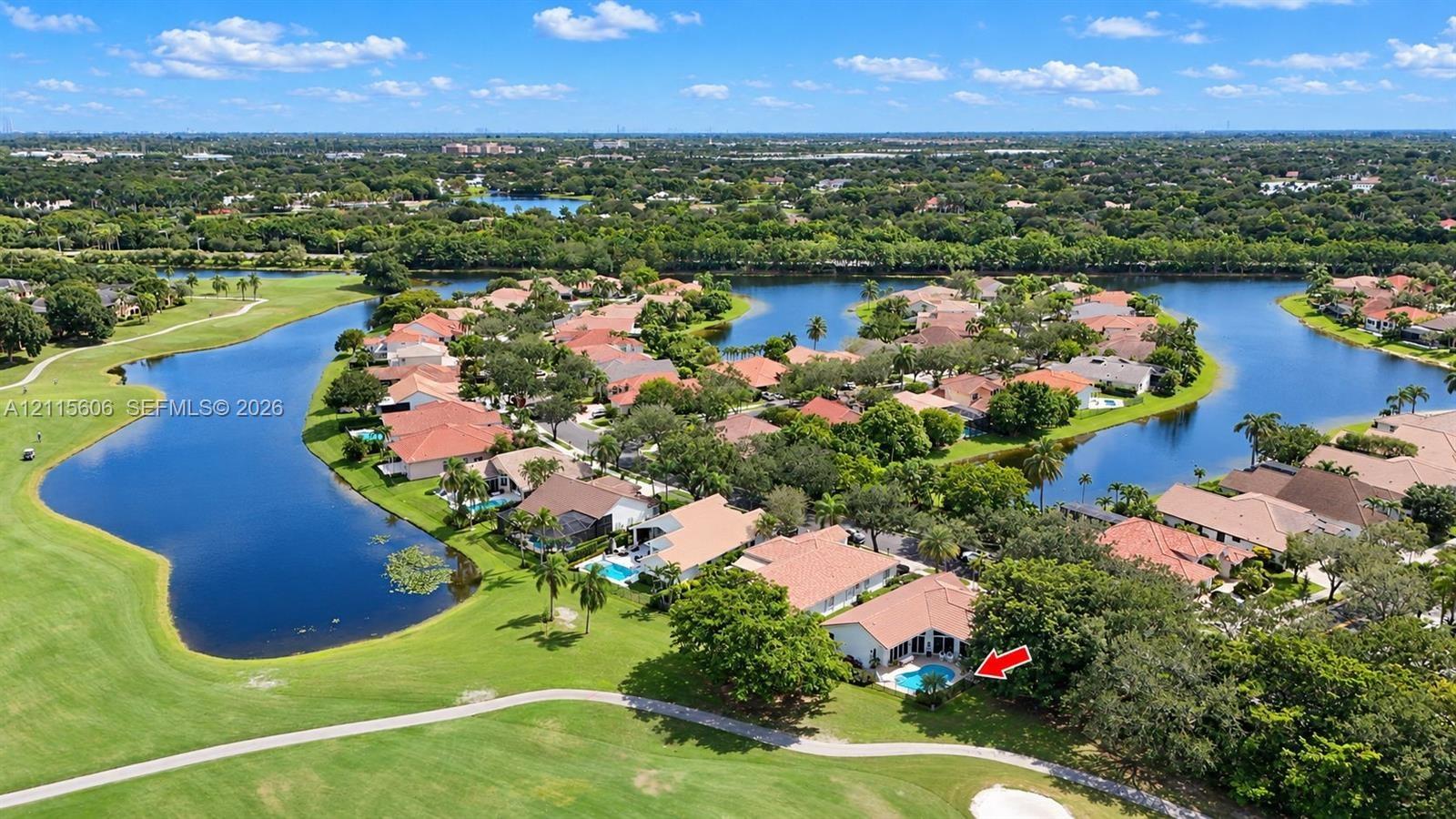 Aerial perspective featuring a waterfront property with an in-ground swimming pool and direct proximity to a golf course