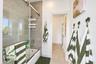 Bathroom featuring a shower-tub combination with a glass sliding door enclosure, tiled wall surround, and large-format floor tile