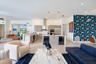Kitchen featuring custom horizontal-grain cabinetry, stainless steel appliances, a subway tile backsplash, and a central island with dual under-counte