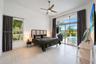 High ceilings featuring a central ceiling fan, large-format tile flooring, oversized windows, and expansive sliding glass doors