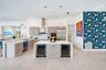 Kitchen featuring light-finish slab cabinetry, quartz countertops, stainless steel appliances, a central island with dual under-counter wine refrigera
