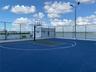 Rooftop basketball court featuring a high-performance surface, integrated lighting system, and full-perimeter chain-link fencing