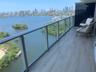 Covered balcony featuring wood-finish flooring and a tempered glass railing