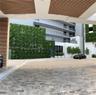 Covered motor court featuring natural stone paving, architectural wood-slat ceiling detailing, a multi-story living green wall, and tiered balconies w