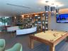 Floor-to-ceiling built-in wooden shelving, recessed ceiling lighting, textured wall-to-wall carpeting, and metal geometric pendant light fixtures